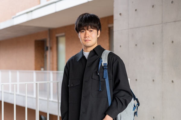 キャンパス内で笑顔で佇む駒井一翔
