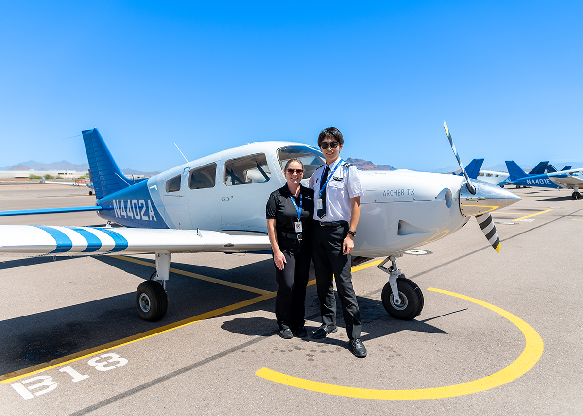 駐機中のArcher TX訓練機（N4402A）の前で記念撮影をする女性インストラクターと日本人パイロット訓練生の画像