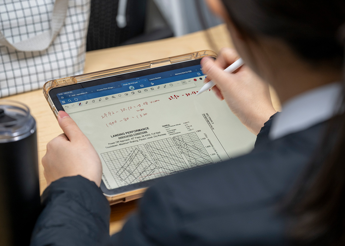 iPad上に表示されたPA28-181 POH（航空機運用マニュアル）のランディングパフォーマンスチャートに、Apple Pencilで計算を書き込み学習する訓練生の画像