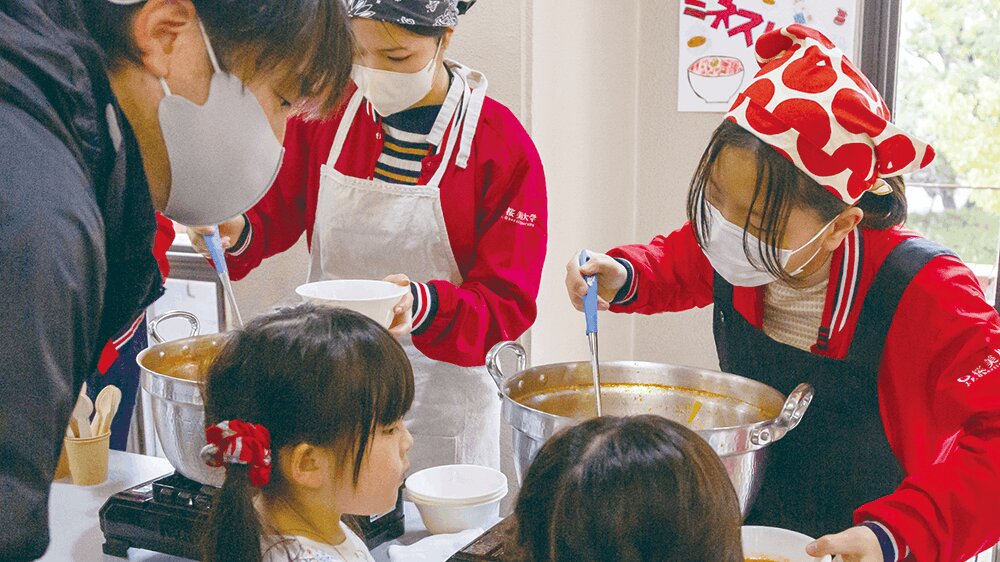 学生が地域の子供達に食事を提供している様子