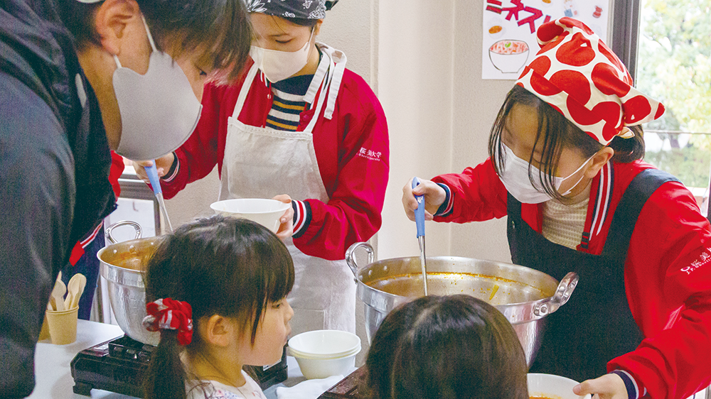 学生が地域の子供達に食事を提供している様子