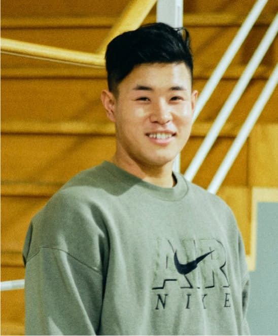 キャンパス内で笑顔で佇む山本　雅樹