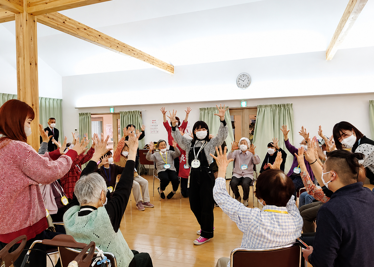 学生が高齢者施設で地域の人とダンスを踊っている様子
