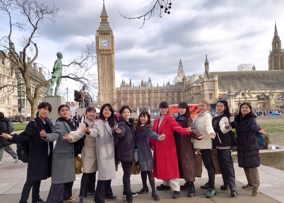 学生たちがロンドンでポーズをとりながら写っている様子