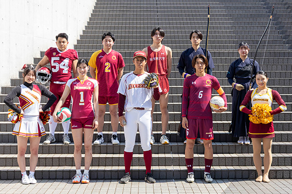 様々なジャンルのスポーツのユニフォームを着た学生の集合写真