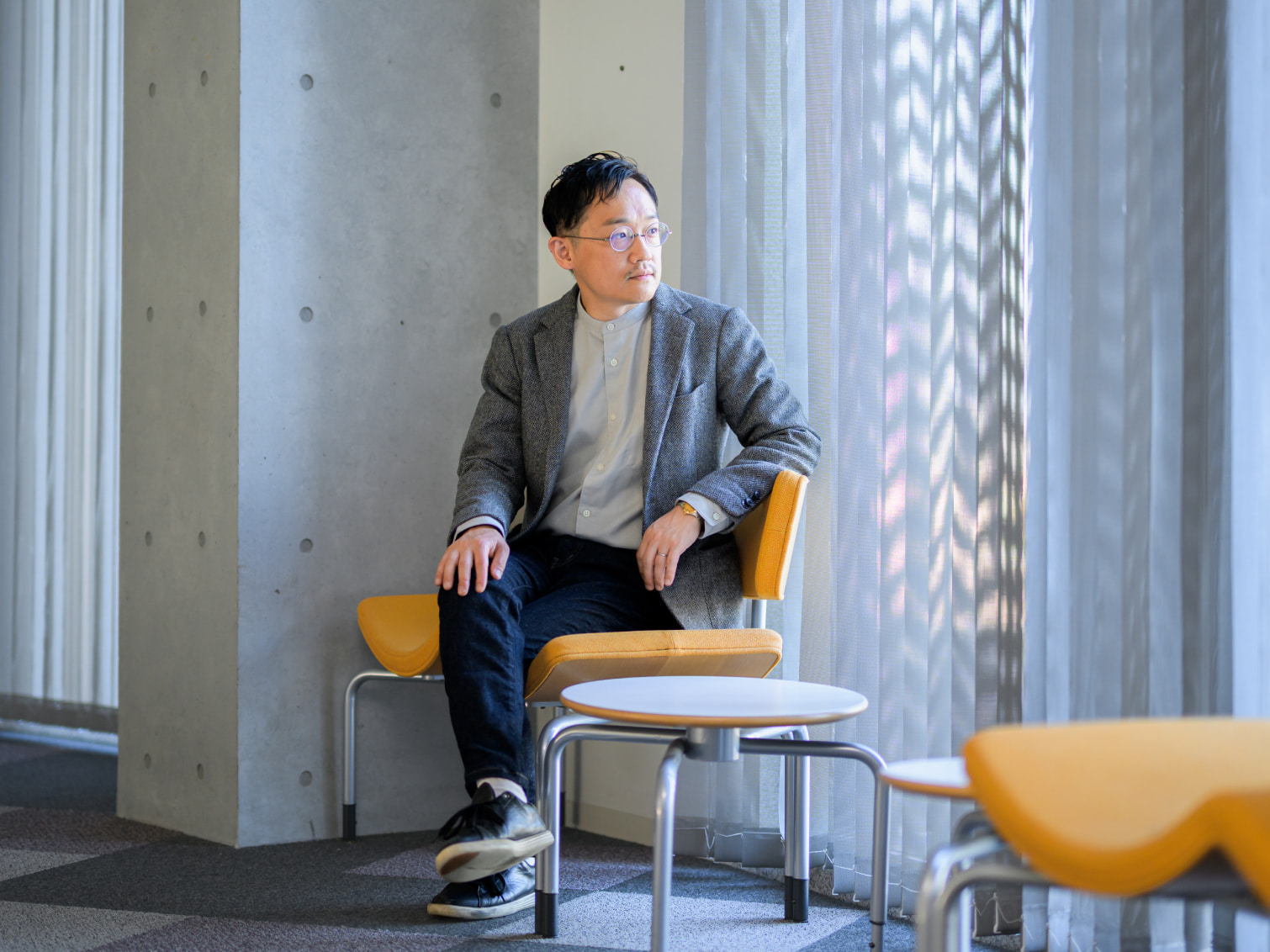 キャンパス内で腰掛ける田中一孝先生