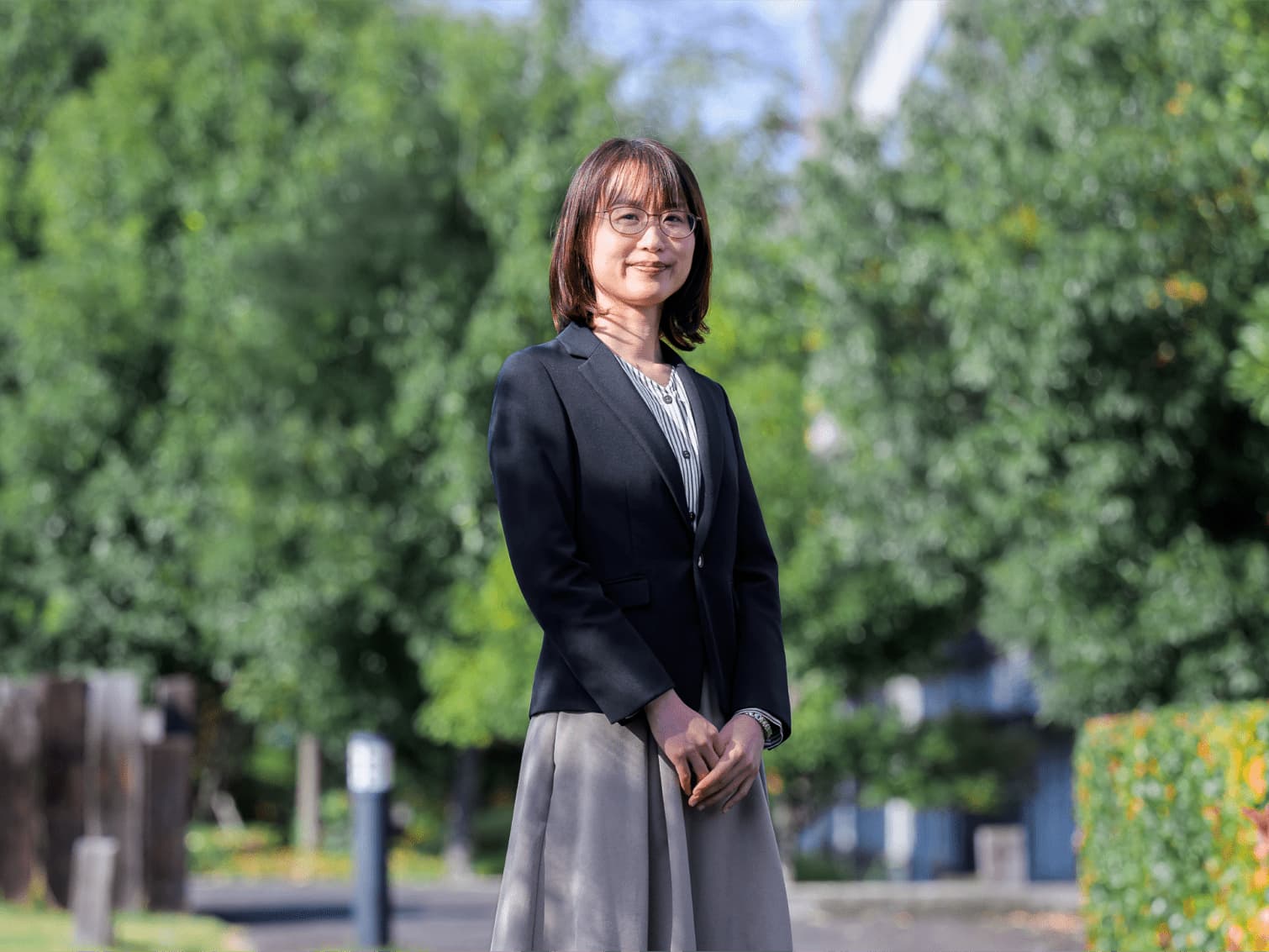 キャンパスの外で佇む有賀雅奈先生
