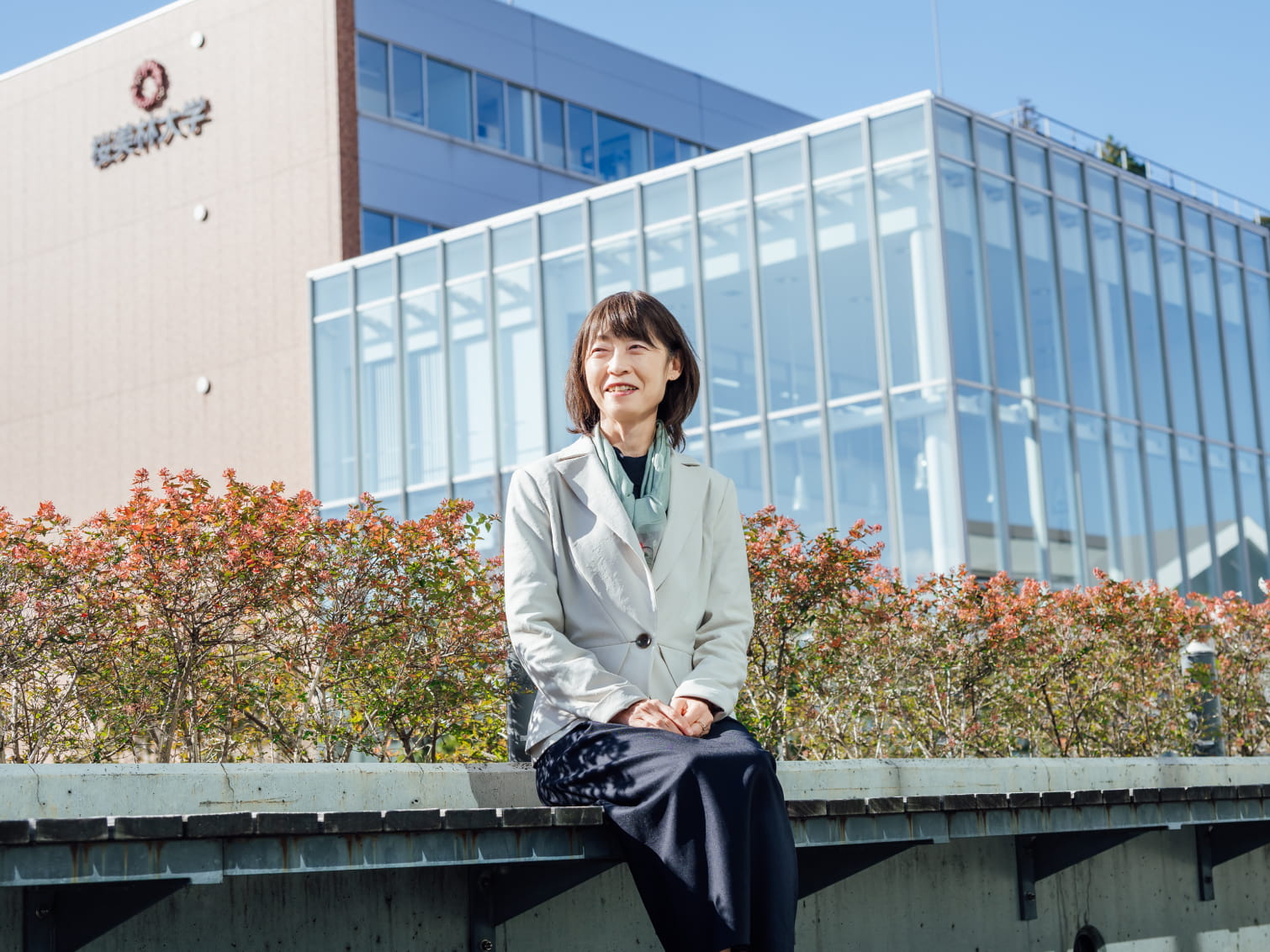 キャンパス内で腰掛ける池田美樹先生