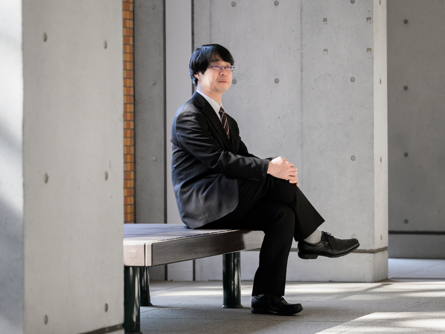 キャンパス内で腰掛ける藤澤太郎先生