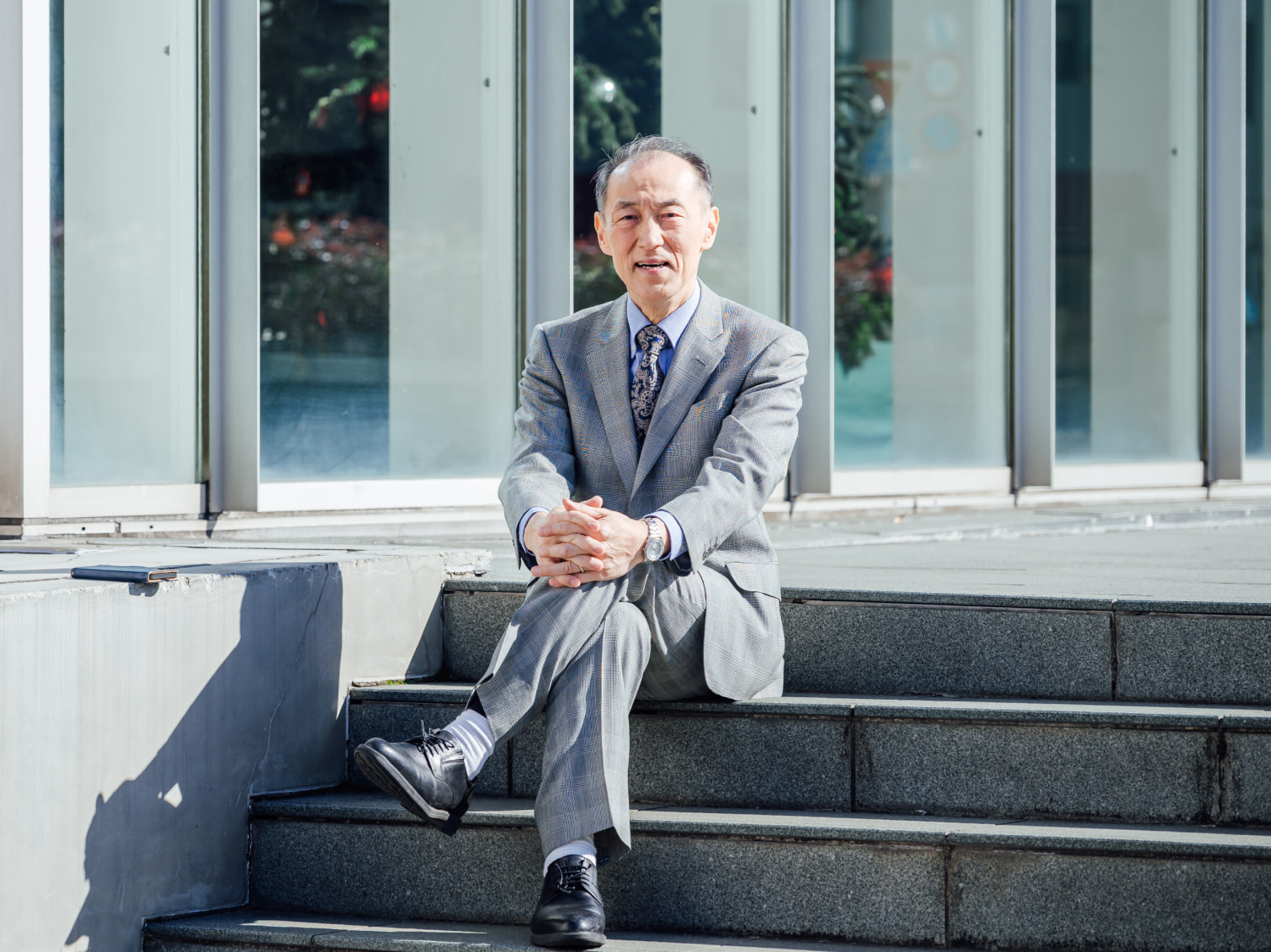 キャンパス内で腰掛ける田中暁龍先生