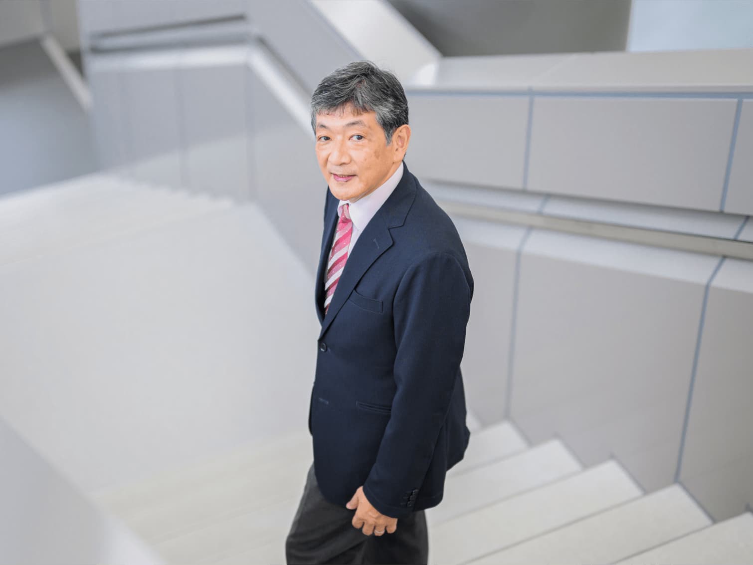 階段で前を見上げる相原弘明先生