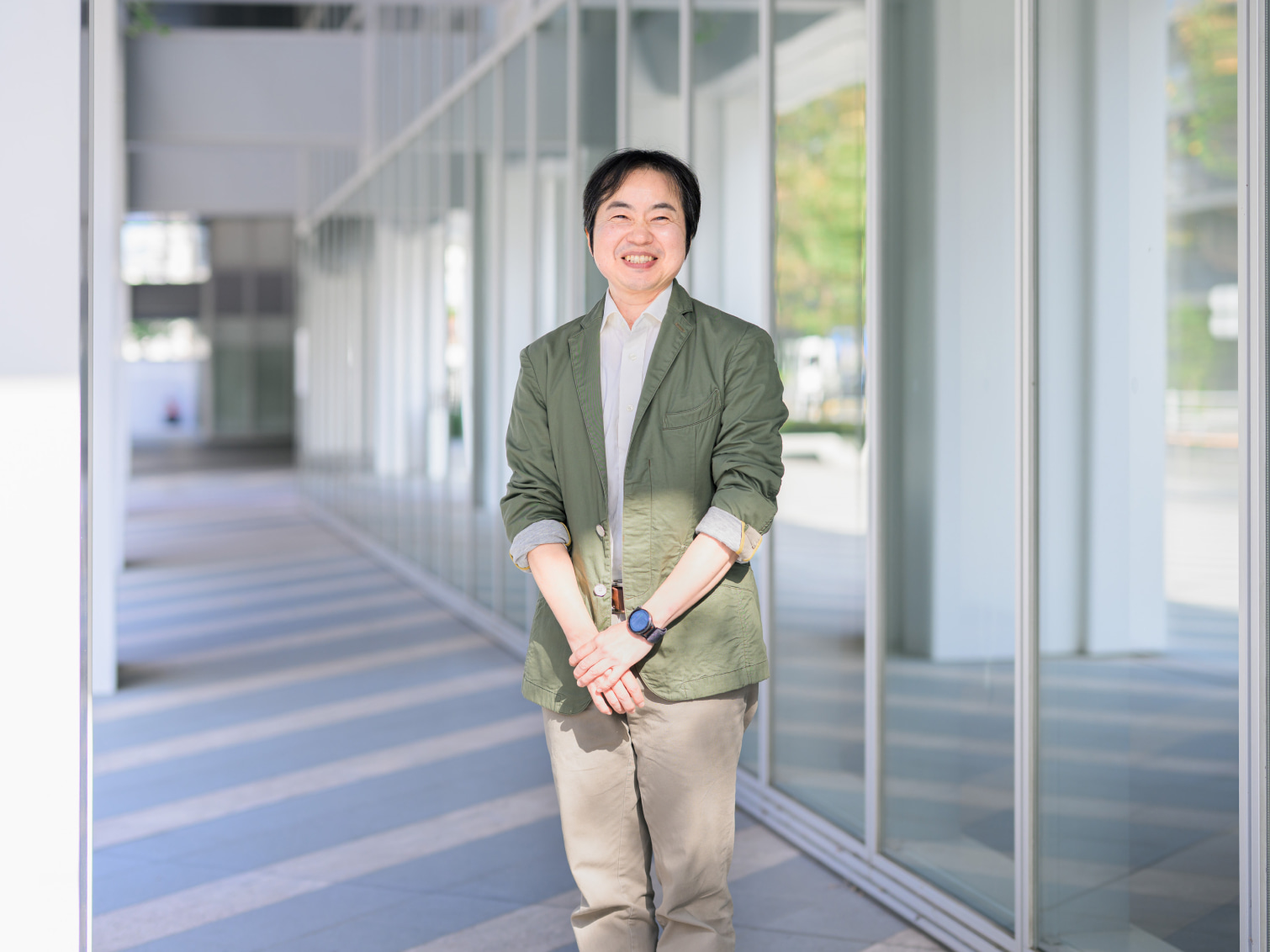 キャンパス内で笑顔で佇む川﨑昌先生