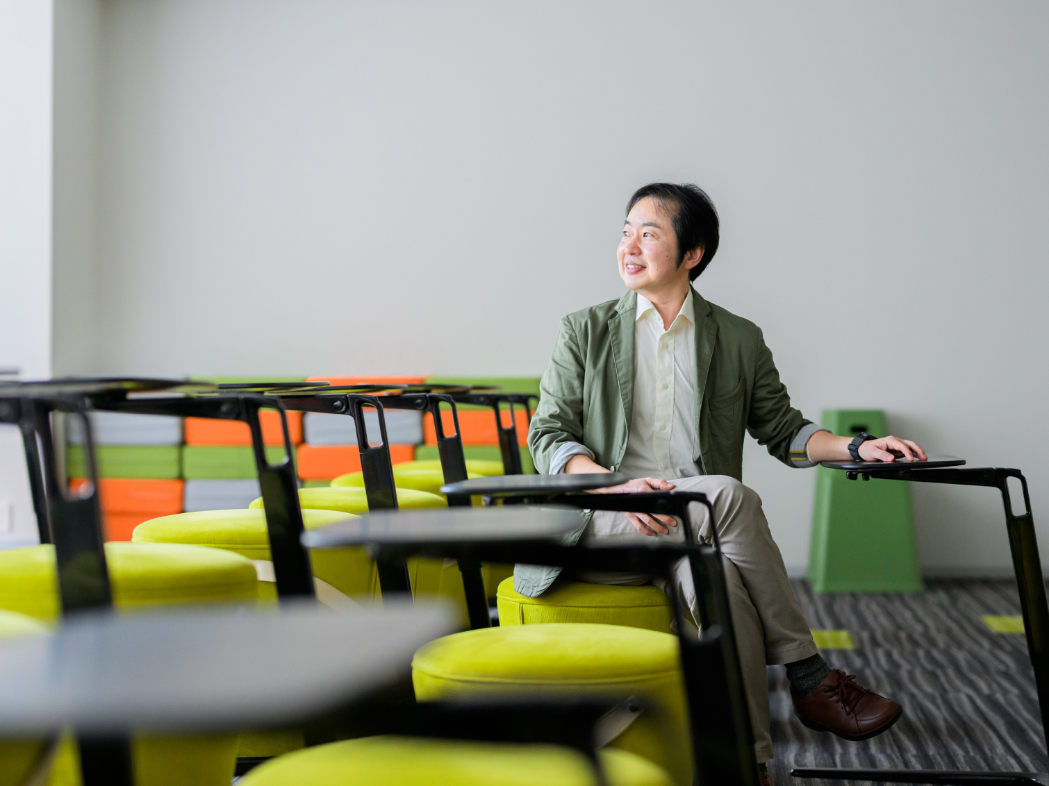 キャンパス内で腰掛ける川﨑昌先生