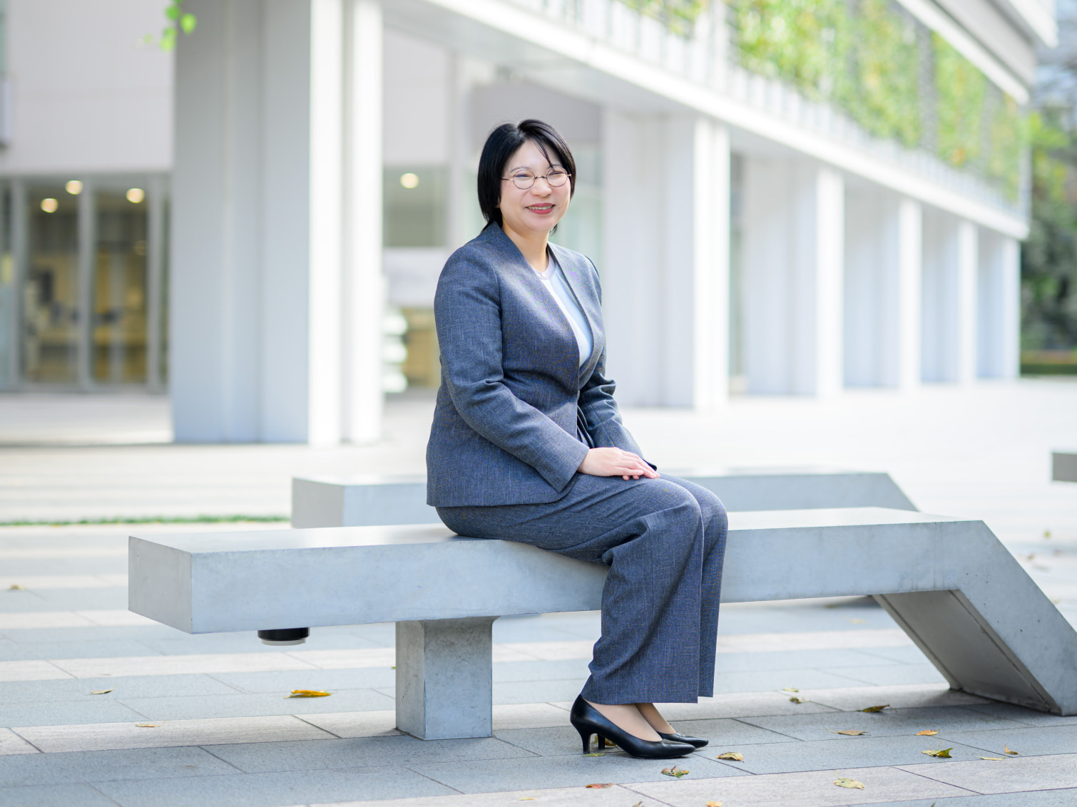 キャンパス内で腰掛ける川﨑友加先生