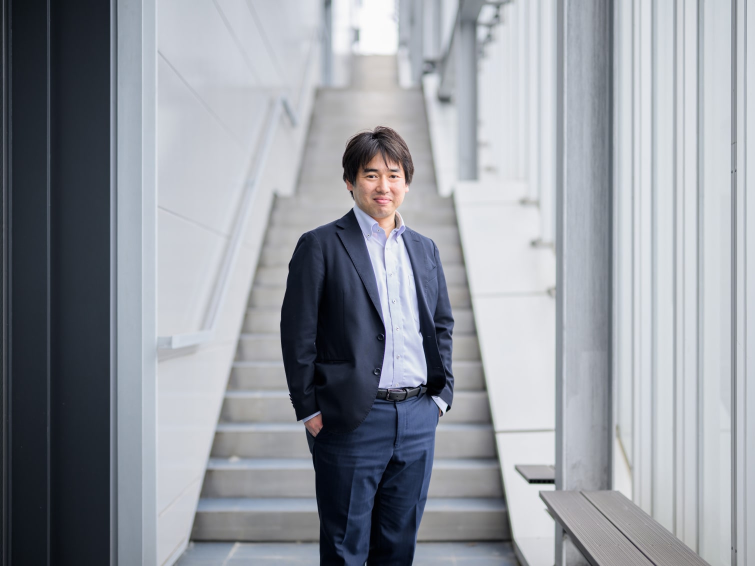 キャンパス内の階段で佇む堺完先生