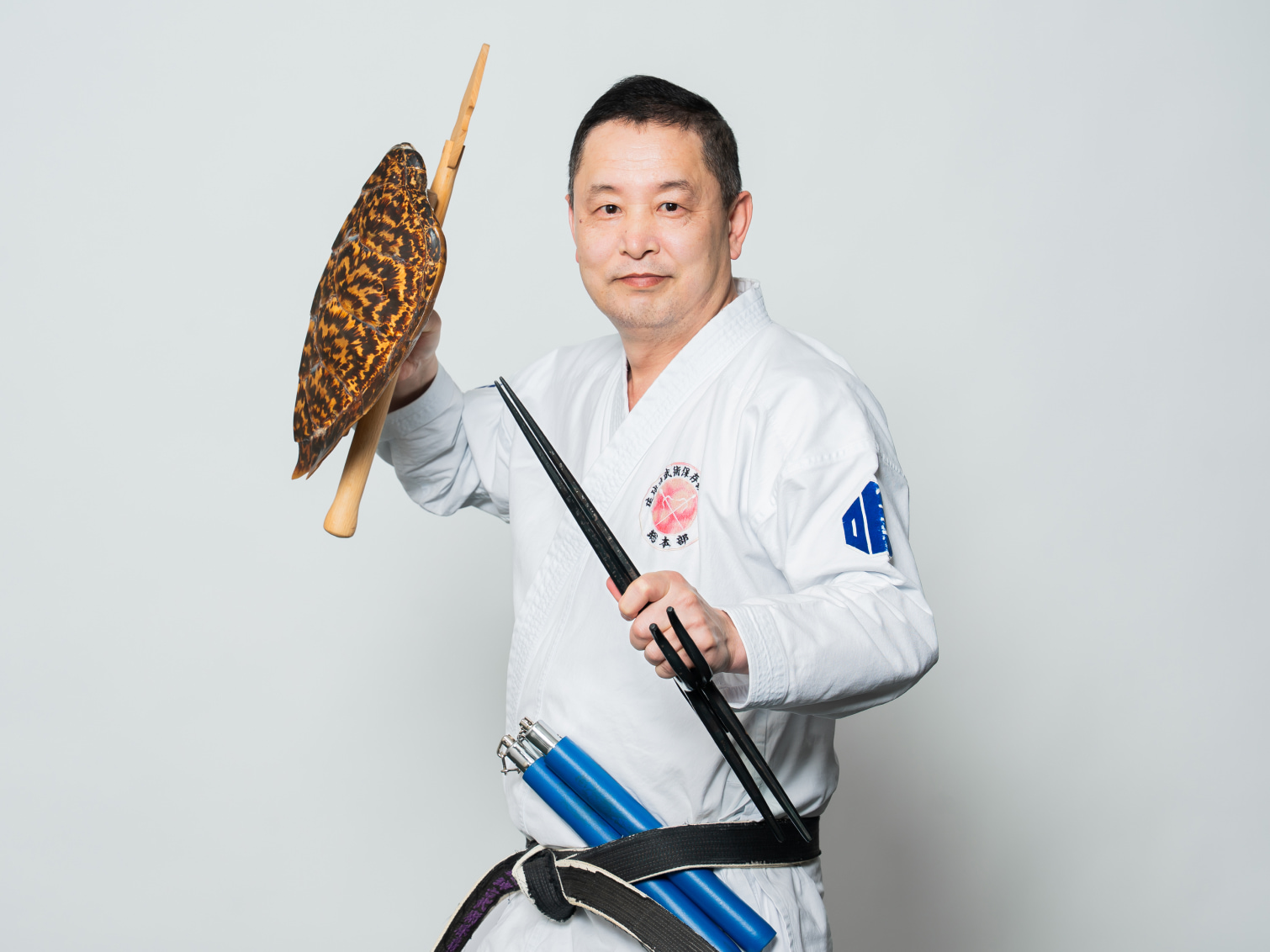 武道の道具を手にポージングする菅沼雲龍先生