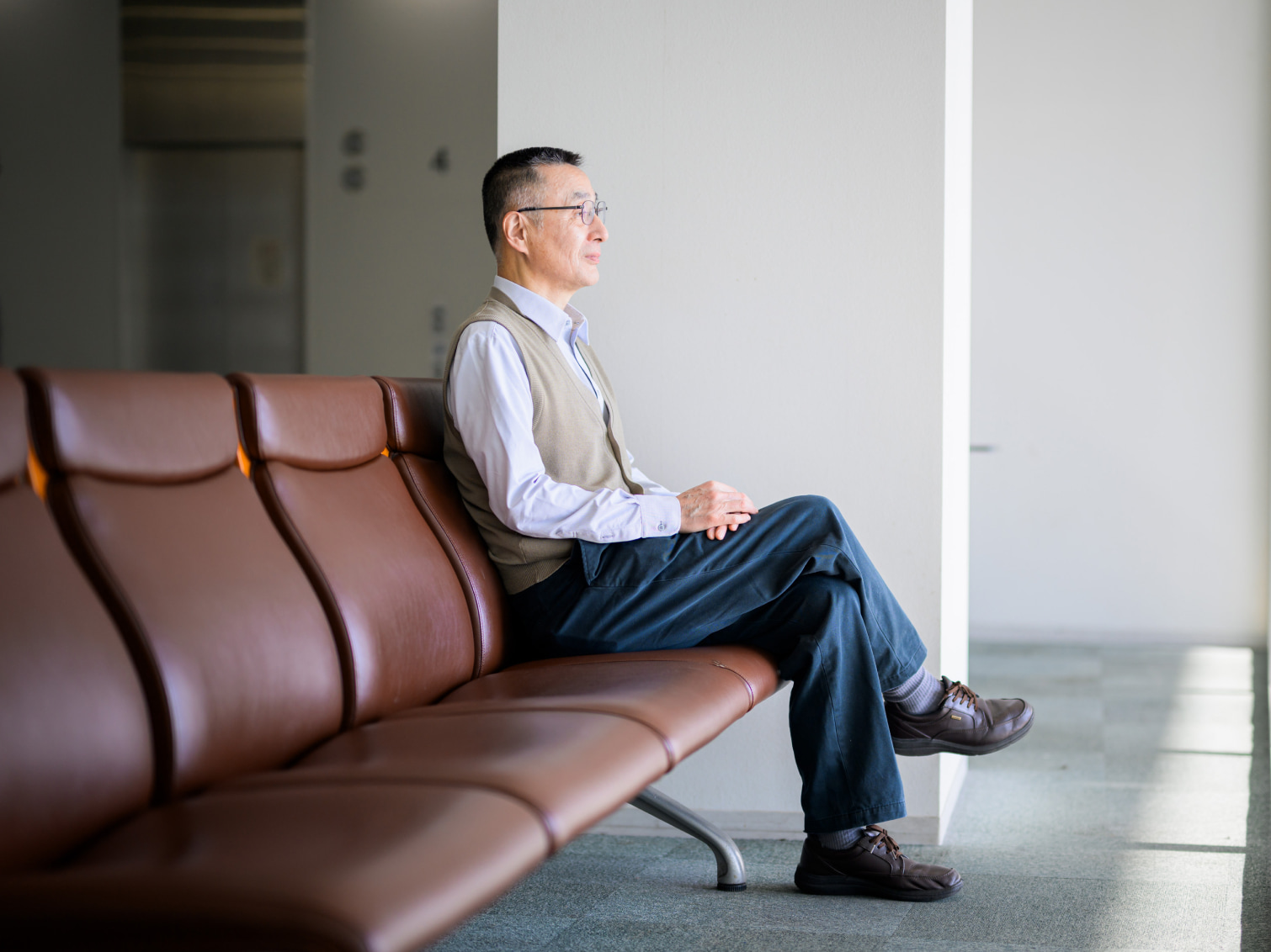 キャンパス内で腰掛ける新野直明先生