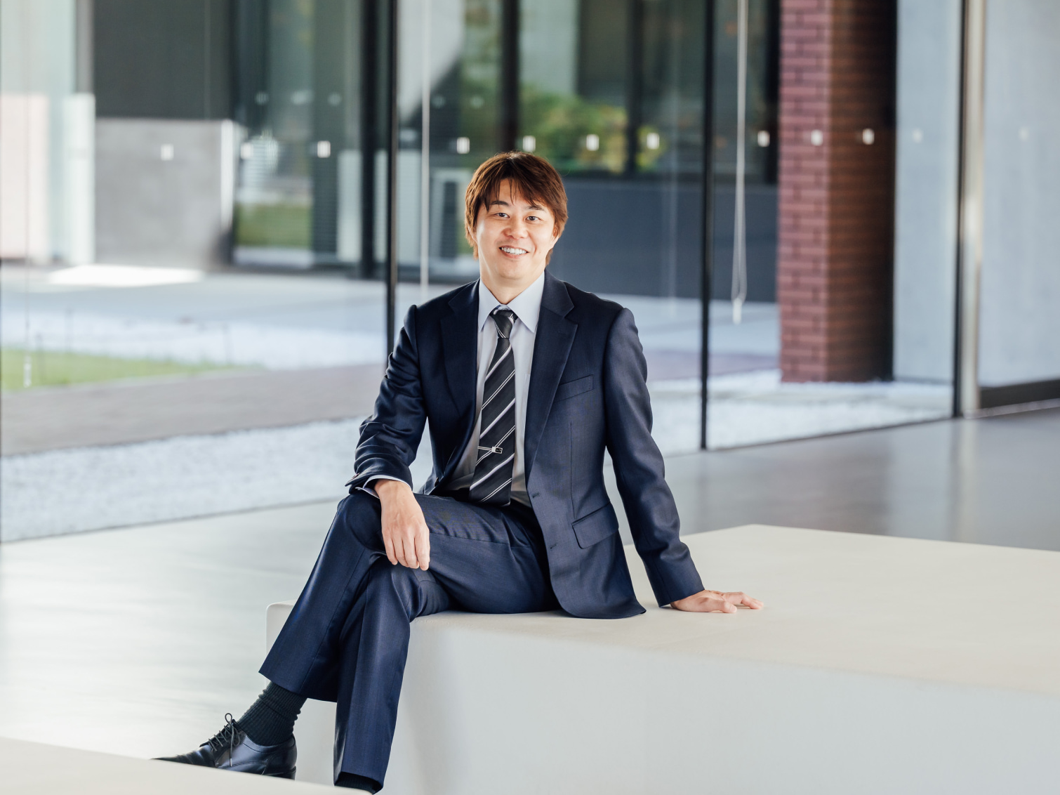 キャンパス内で腰掛ける國友淑弘先生